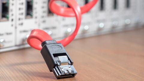 Server (Symbolbild) Stecker mit rotem Kabel vor Steckplätzen eines Servers.